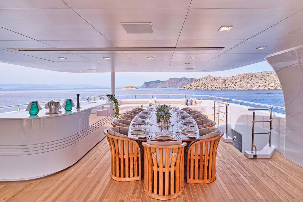 Dining and a fully equipped bar under the spacious sun deck's hardtop, seating forward, sun lounge and sunpads aft