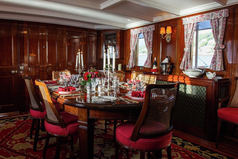 Dine in the mahogany panelled dining room, the beating heart of the yacht