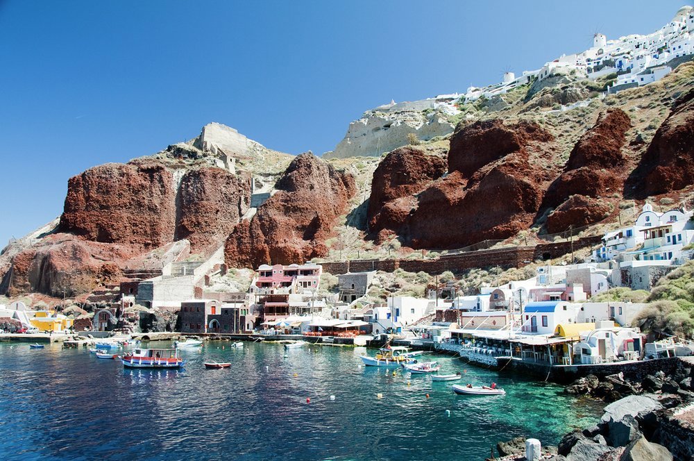 Ammoudi is a lively fishing village at the foot of the distinctive red cliffs below the historic town of Oia, Santorini